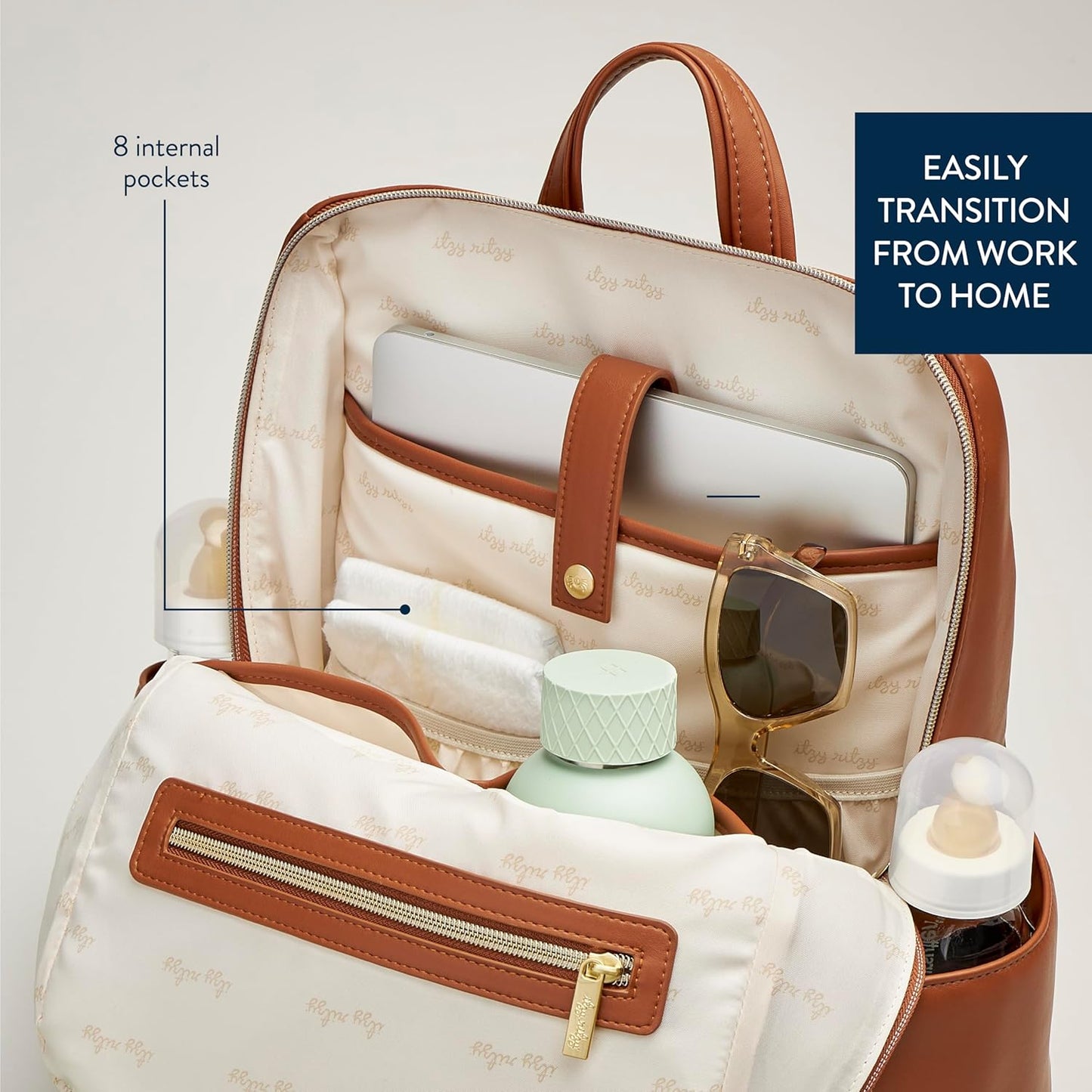 Itzy Ritzy Eras Diaper Bag Backpack – Large Capacity Backpack Diaper Bag Featuring Sleek Design, 15 Pockets, Changing Pad, Stroller Straps, and Luggage Sleeve (Cognac)